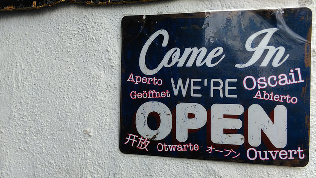 Sign reading 'Come in, we are open' in many languages