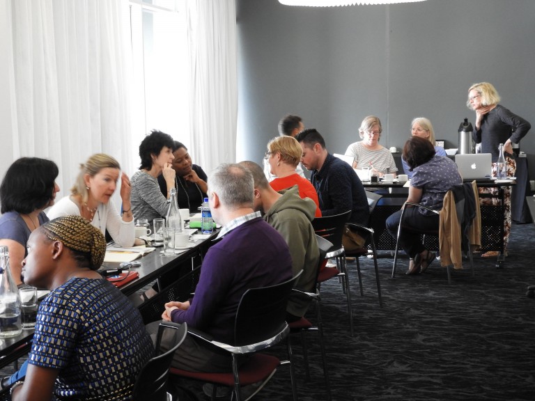 A dozen PhD students discussing ideas to improve their work